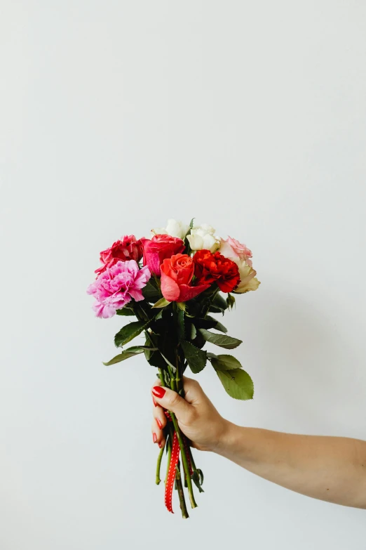 a person holding a bunch of flowers in their hand, multiple colors, holding a red rose, pinks, of letting go