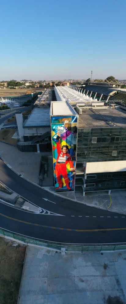 a colorful mural on the side of a building, inspired by Alonso Vázquez, pexels contest winner, in future airport rooftop, aerial viewyoji shinkawa, wearing red and yellow hero suit, portugal