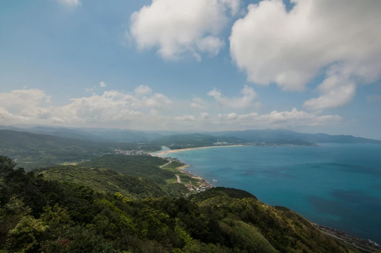 a large body of water sitting on top of a lush green hillside, inspired by Kōno Michisei, unsplash contest winner, mingei, overlooking the beach, murata range, seaview, shan shui