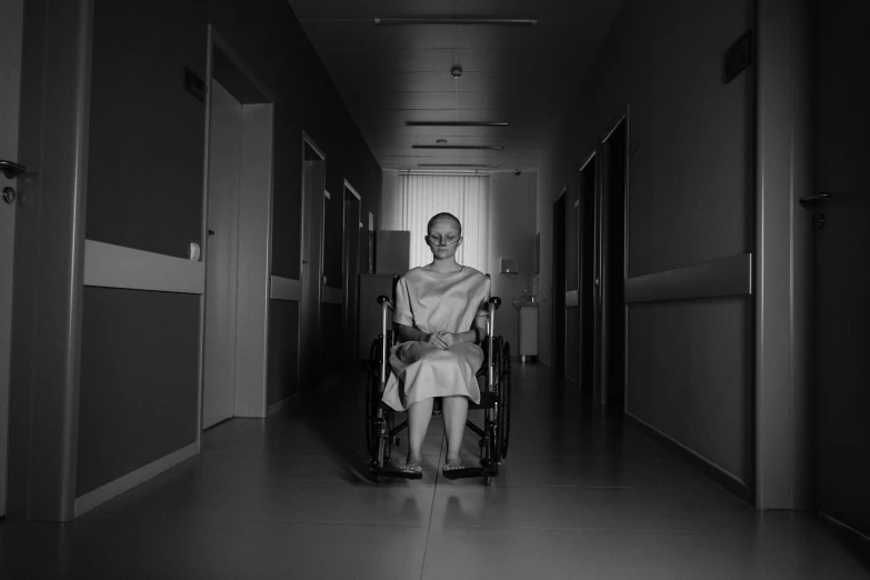 a black and white photo of a man in a wheelchair, a black and white photo, by Adam Marczyński, pexels contest winner, nurse girl, horror movie, princess, hospital lighting
