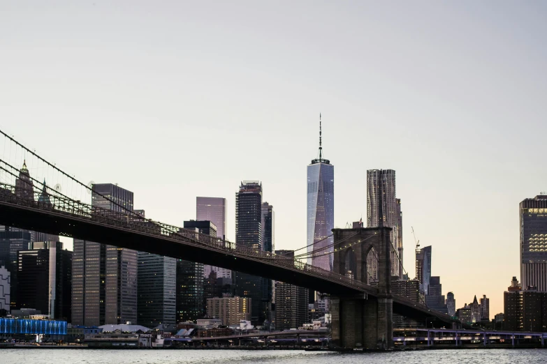 a bridge over a body of water with a city in the background, inspired by Thomas Struth, pexels contest winner, new york buildings, medium format, late afternoon, skyline showing