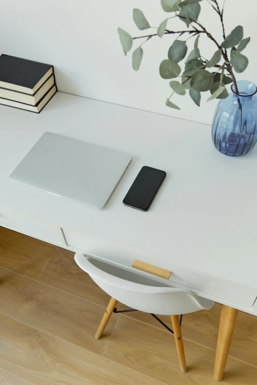a laptop computer sitting on top of a white desk, trending on pexels, minimalism, scanning items with smartphone, minimalist furniture, attractive photo, full width