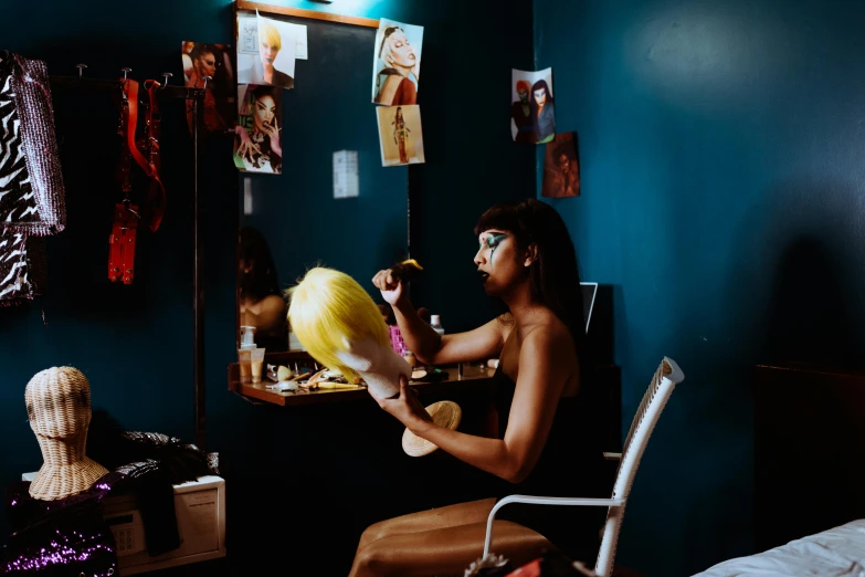 a woman sitting at a desk in front of a mirror, pexels contest winner, visual art, blue undergarments, drag queen, holding maracas, profile image