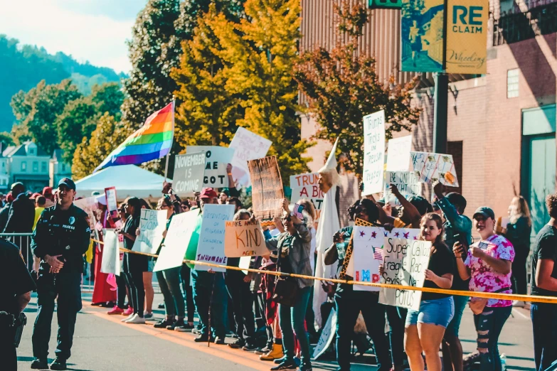 a group of people that are standing in the street, pexels, renaissance, trans rights, colorful signs, fall season, high school