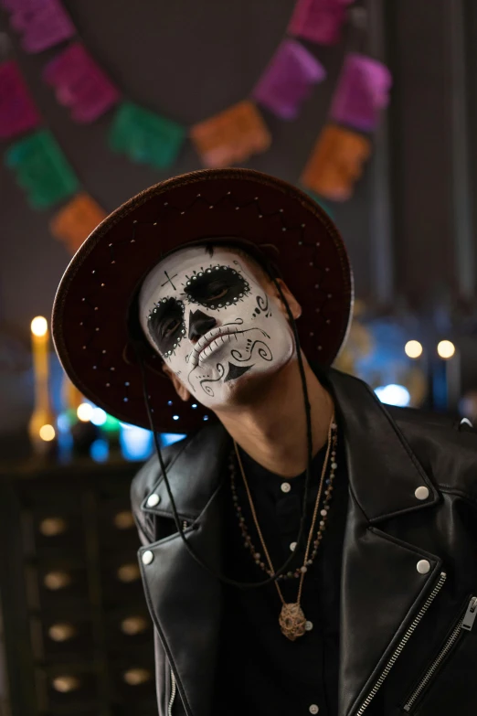 a man with a skull face painted on his face, trending on pexels, wearing sombrero, a man wearing a black jacket, lights, promotional image