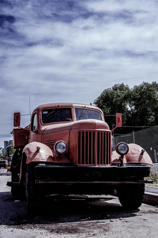 an old red truck parked on the side of the road, a colorized photo, by Sven Erixson, unsplash, photorealism, orange tint, menacing look, paul barson, historical photo