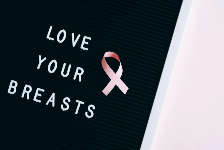 a pink ribbon with the words love your breasts on it, a poster, trending on unsplash, feast, yeast, exist, caaats