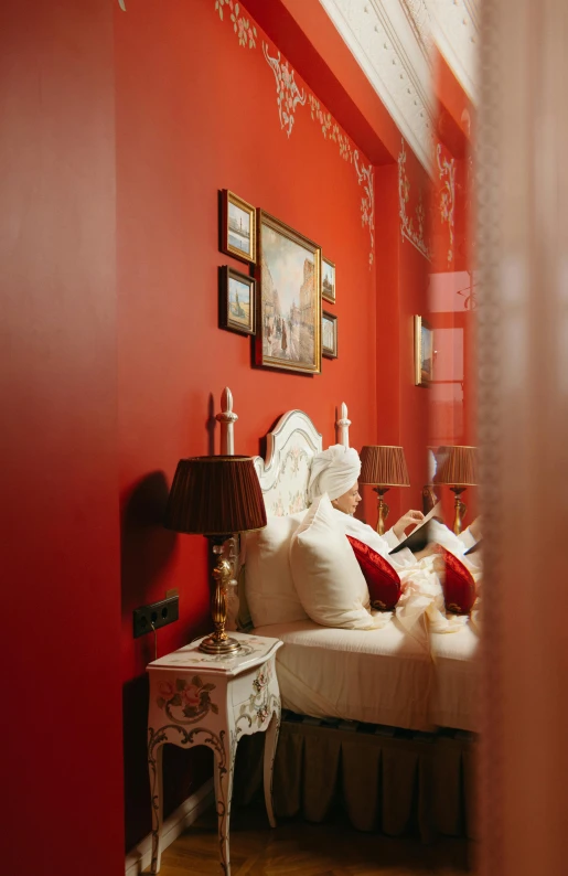 a bed room with a neatly made bed and red walls, inspired by Riad Beyrouti, rococo, red paint detail, high angle shot, cream, reflecting