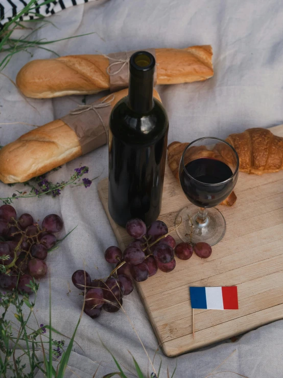 a bottle of wine sitting on top of a wooden cutting board, by Raphaël Collin, french flag, baking french baguette, promo image, alessio albi
