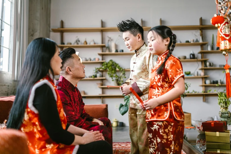 a group of people standing around a living room, inspired by Cui Bai, pexels contest winner, cloisonnism, authentic costume, avatar image, husband wife and son, te pae
