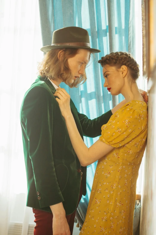 a man standing next to a woman in a yellow dress, inspired by Balthus, trending on pexels, eleanor tomlinson, green clothing, dreamy feeling, 1 9 1 0 s style