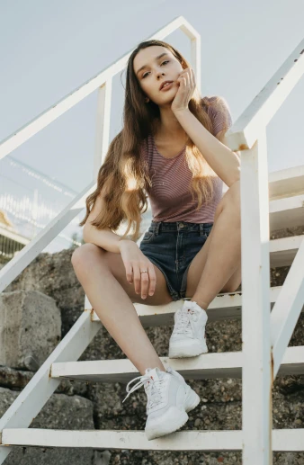 a woman sitting on a set of stairs, trending on pexels, wearing shorts and t shirt, #oc, sneaker photo, young with long hair