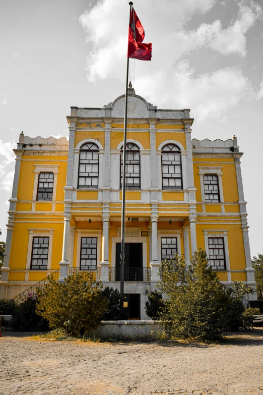 a large yellow building with a flag on top of it, inspired by Almada Negreiros, ottoman sultan, profile image, exterior photo, grand library