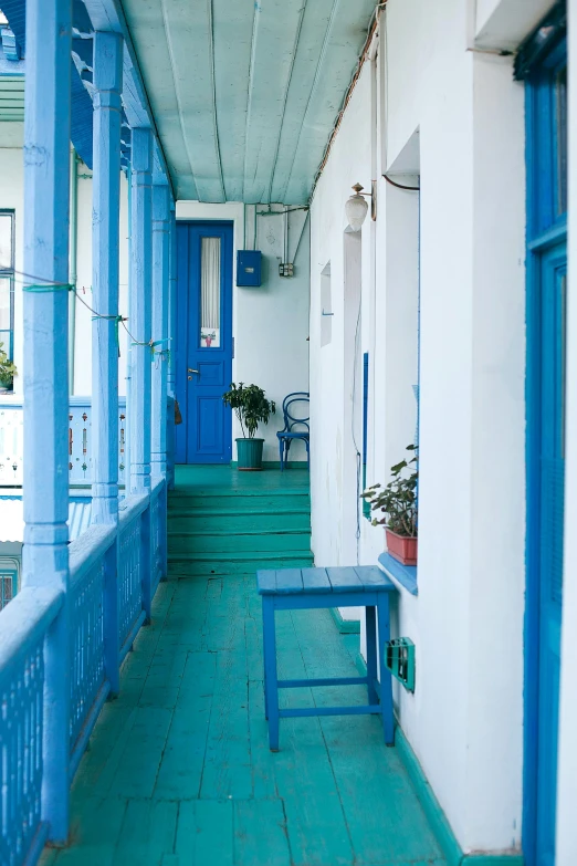 a blue and white porch with a blue bench, inspired by Isaac Levitan, art nouveau, green alleys, jerez, hallway, whitewashed buildings