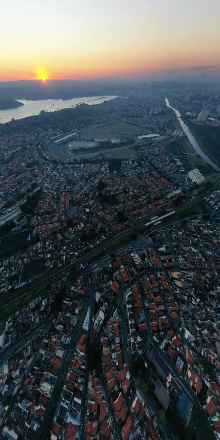 an aerial view of a city at sunset, a detailed matte painting, location ( favela ), hyperrealism 8k, freeway, low quality photo