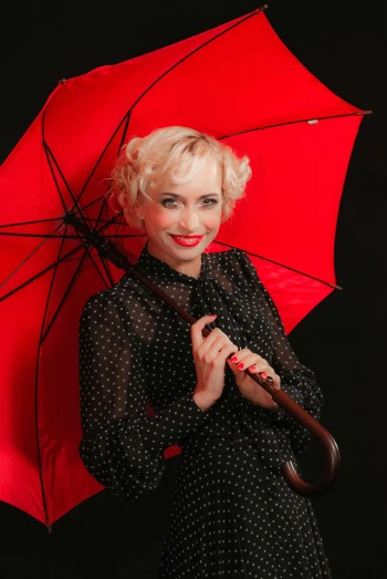 a woman in a polka dot dress holding a red umbrella, a portrait, inspired by Grete Stern, pexels, demur, square, blonde women, anna nikonova aka newmilky