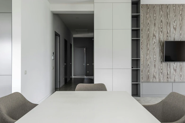 a white table and some chairs in a room, inspired by David Chipperfield, unsplash contest winner, minimalism, cupboards, flat grey color, neo kyiv, straight camera view