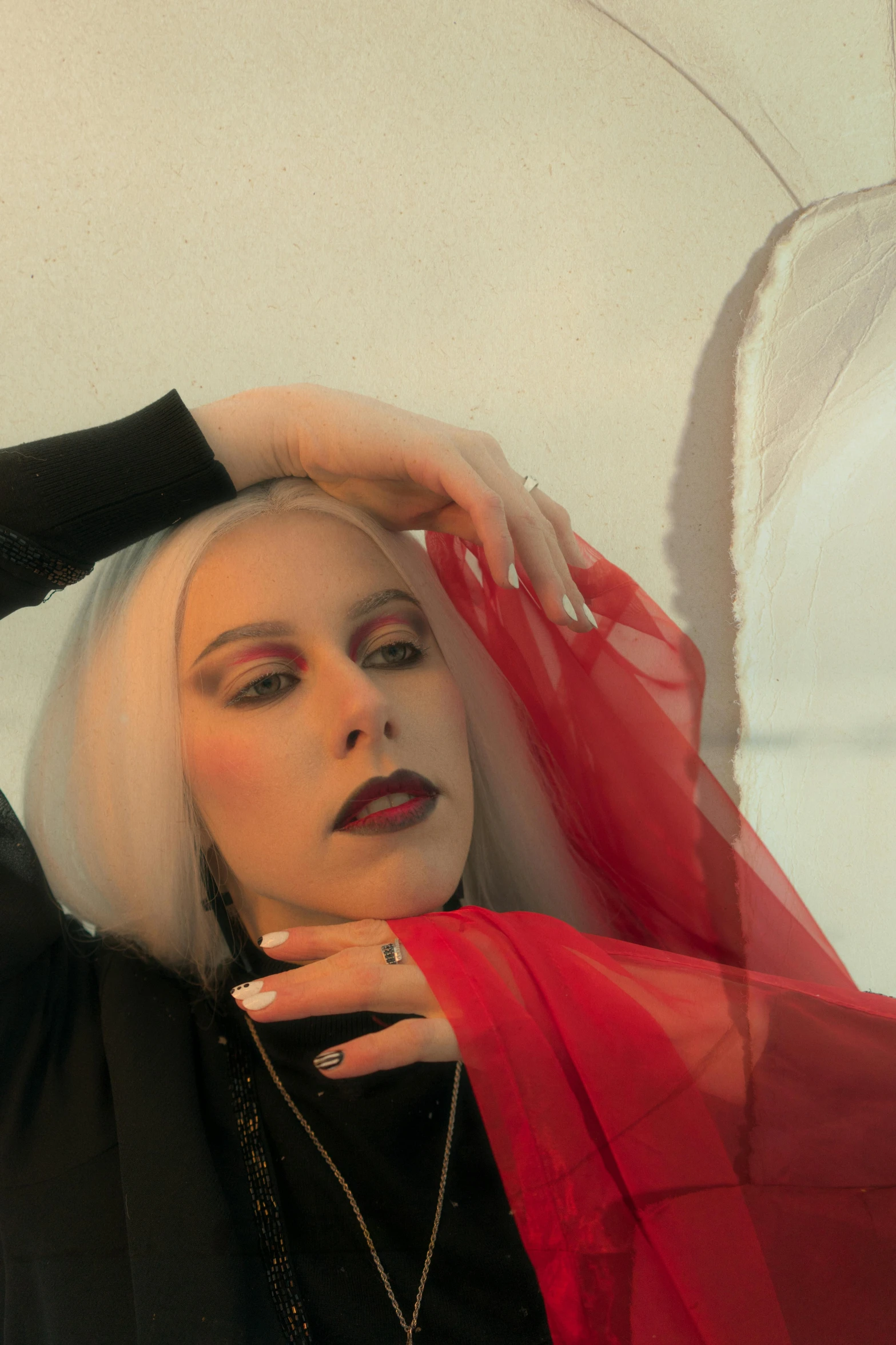 a woman in a black top and red scarf, an album cover, inspired by Louisa Matthíasdóttir, trending on pexels, aestheticism, intense white hair, androgynous vampire, long fingers, drag