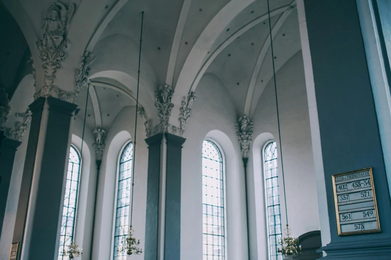 a living room filled with furniture and tall windows, a photo, unsplash contest winner, neoclassicism, standing inside of a church, grey and blue theme, profile image, steel archways