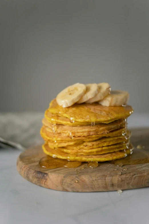 a stack of pancakes sitting on top of a wooden cutting board, pumpkin, banana, w 1 9 2 0, medium close shot