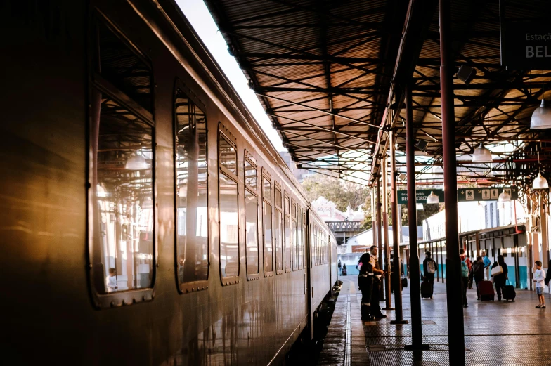 a group of people standing on a platform next to a train, by Kristian Zahrtmann, pexels contest winner, art nouveau, warm sunlight shining in, australian, indore, conde nast traveler photo