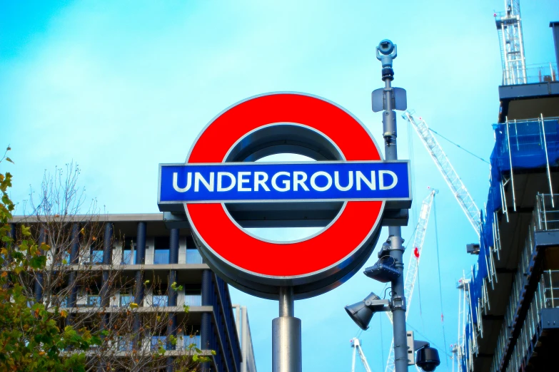 a close up of a sign with a building in the background, shutterstock, underground comix, 🚿🗝📝, square, under blue, view from the ground