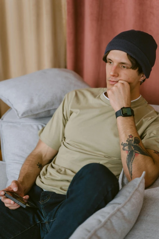 a man sitting on a bed with a laptop, inspired by Seb McKinnon, trending on pexels, crossed arms, wearing baseball cap, greg rutowski, wears a watch