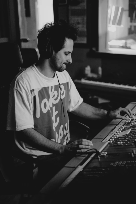 a man that is sitting in front of a keyboard, a black and white photo, inspired by Anthony Angarola, studio recording, mixing, discord profile picture, casually dressed