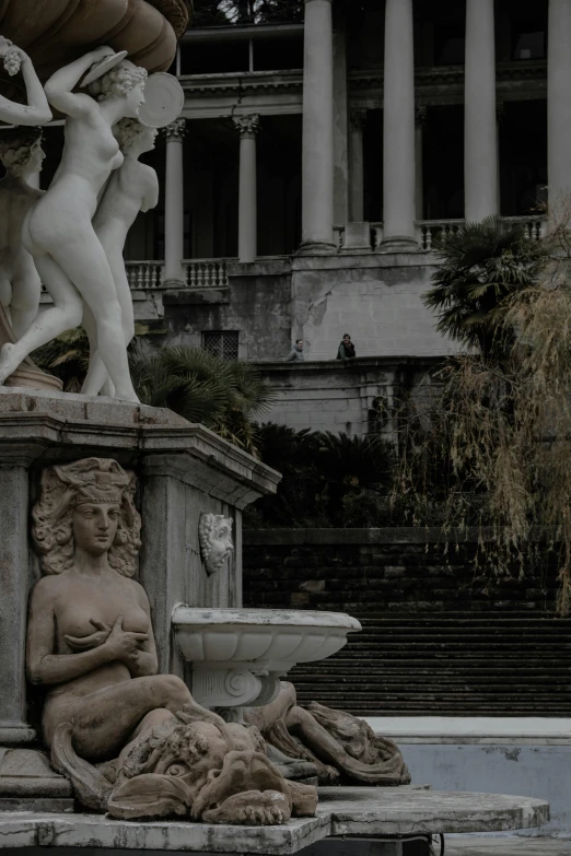 a fountain with statues in front of a building, by Carlo Martini, pexels contest winner, neoclassicism, promo image, sensual gloomy, made of carrara marble, low quality photo