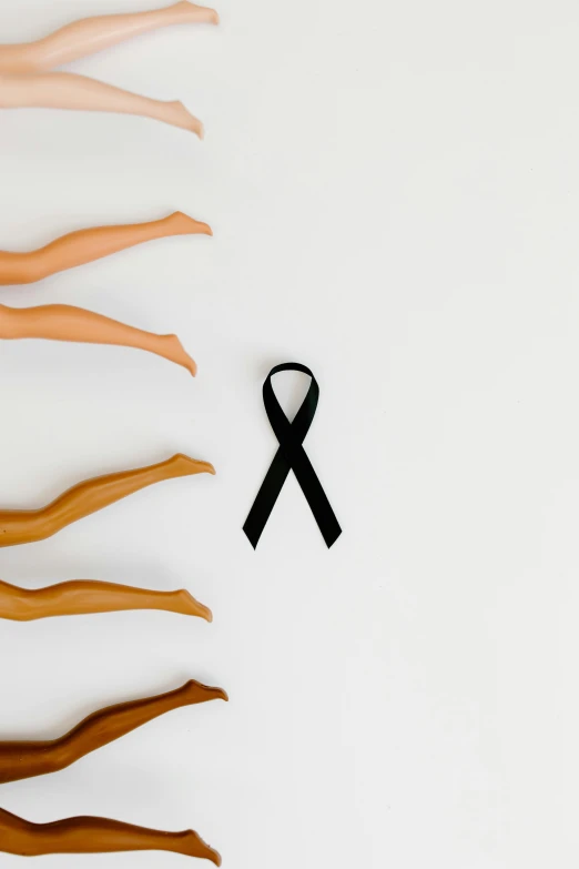 a number of wooden hands with a black ribbon, by Gavin Hamilton, trending on unsplash, antipodeans, black bra, shows a leg, white ribbon, tumours