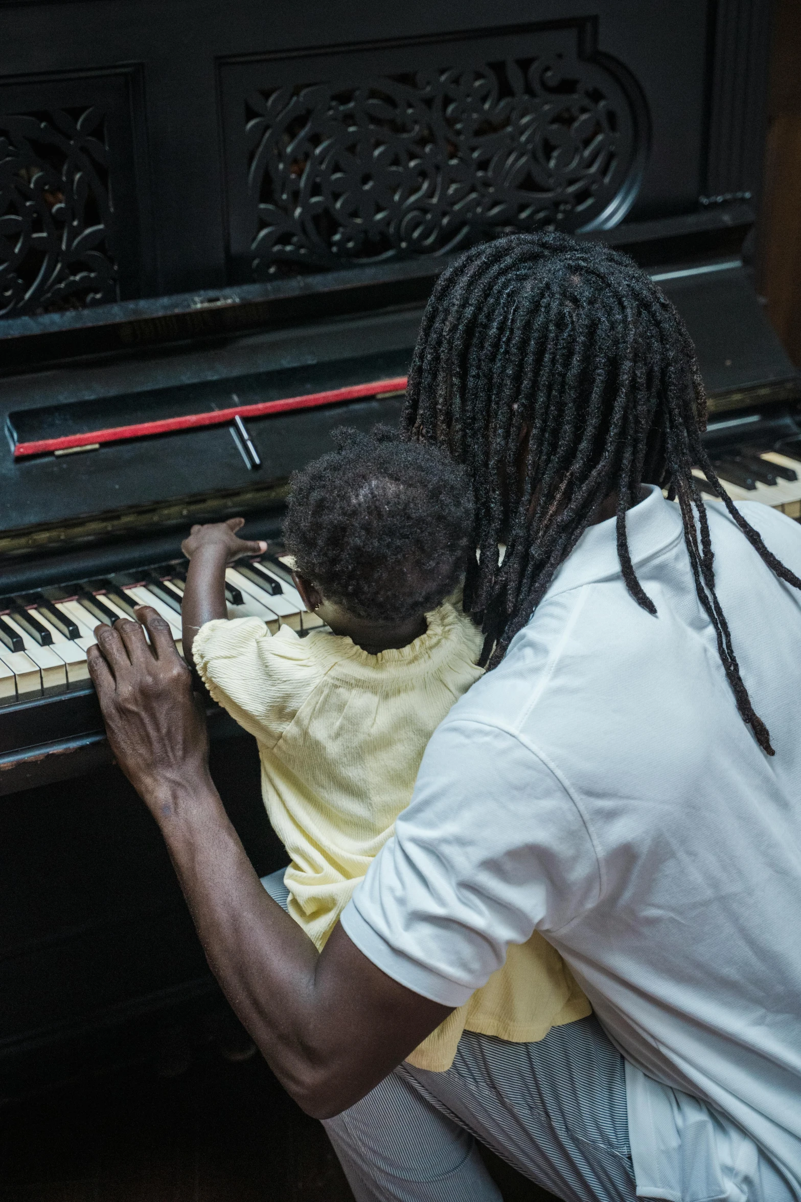 a man playing a piano with a child, black arts movement, sza, multiple stories, jamaican, 15081959 21121991 01012000 4k