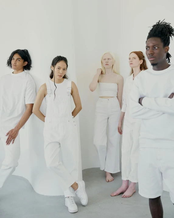 a group of women standing next to each other, inspired by Vanessa Beecroft, trending on unsplash, wearing white clothes, genderless, wearing a track suit, in white room