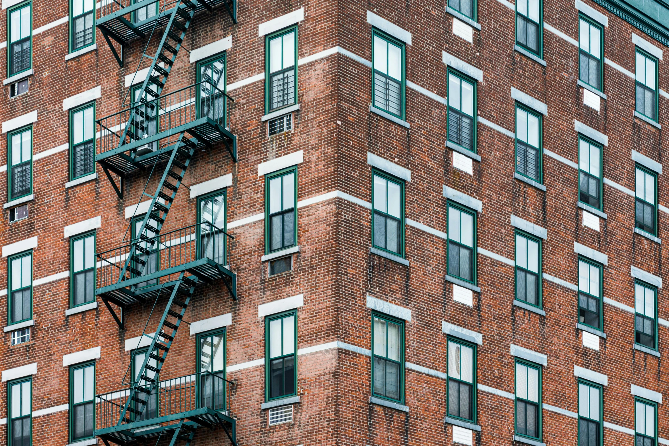 a tall red brick building with lots of windows, a photo, inspired by Elsa Bleda, pexels contest winner, highrise made up staircases, a green, ignant, new england architecture