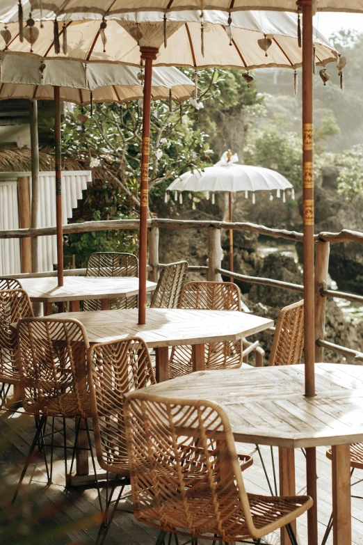 a number of tables with umbrellas near a body of water, a portrait, breakfast at las pozas, canyon, straw, studio shot