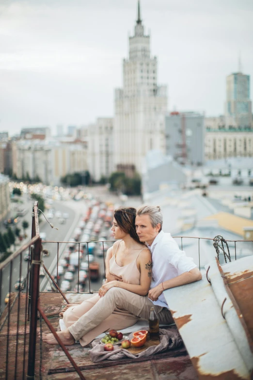 a man and woman sitting on top of a roof, by Alexey Venetsianov, unsplash contest winner, neo-romanticism, with stalinist style highrise, square, romantic, фото девушка курит