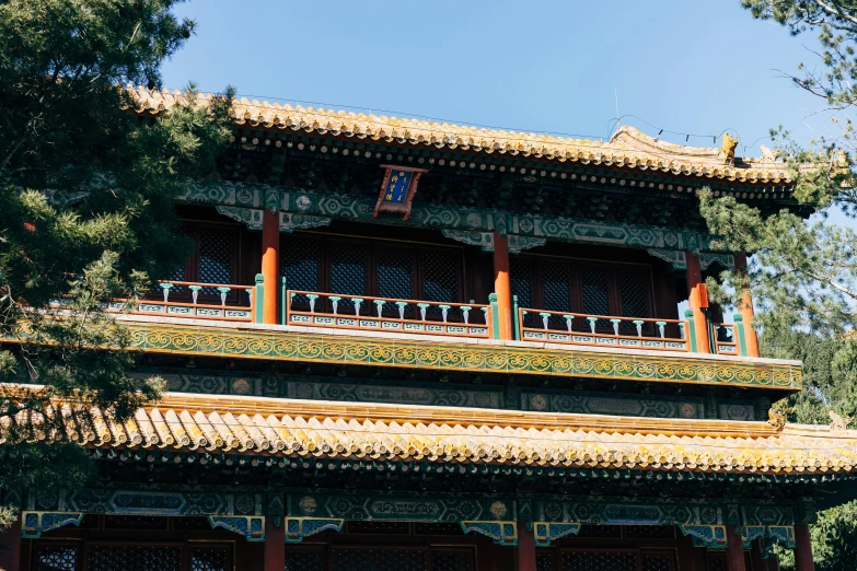 a man sitting on a bench in front of a building, inspired by An Zhengwen, trending on unsplash, cloisonnism, ornate palace made of green, view from below, square, archway