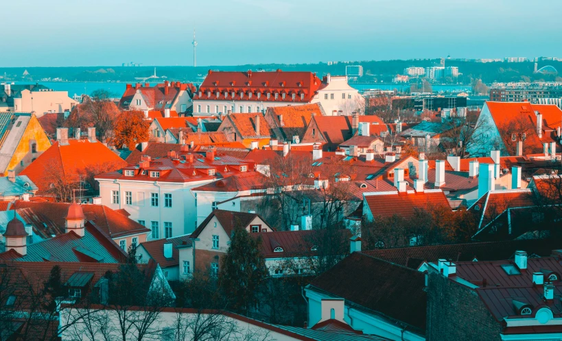 a view of a city from the top of a hill, by Adam Marczyński, pexels contest winner, art nouveau, orange roof, capital of estonia, bright colors with red hues, square