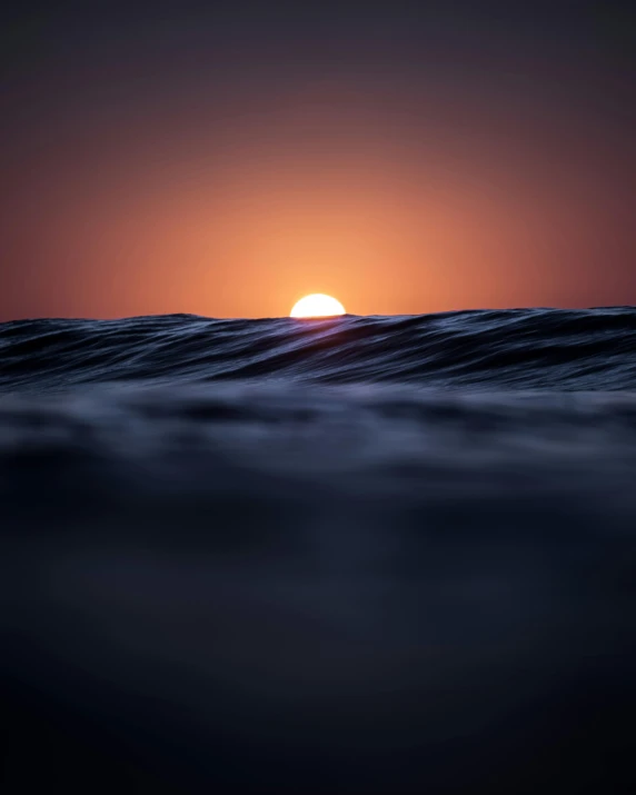 the sun is setting over a body of water, an album cover, unsplash contest winner, minimalism, turbulent waves, depth of field ”, today\'s featured photograph 4k, dark ocean