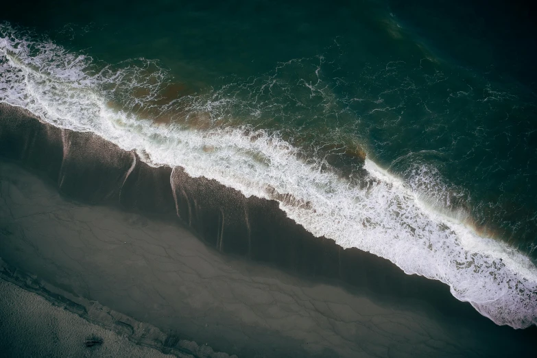 a large body of water next to a sandy beach, pexels contest winner, hurufiyya, ocean spray, down there, dark ocean water, photo 8 k