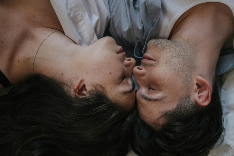a man and a woman laying on top of a bed, trending on pexels, close face view, head looking up, romeo and juliet, two male