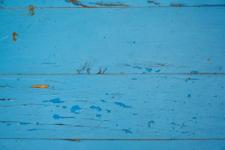 a close up of a wooden surface with blue paint, by Elsa Bleda, pexels contest winner, minimalism, cyan and gold scheme, wooden table, pbr textures, blue / grey background