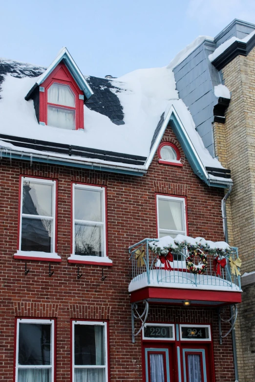 a house with a lot of snow on the roof, a photo, inspired by A. J. Casson, art nouveau, festive colors, montreal, medium close shot, multiple stories