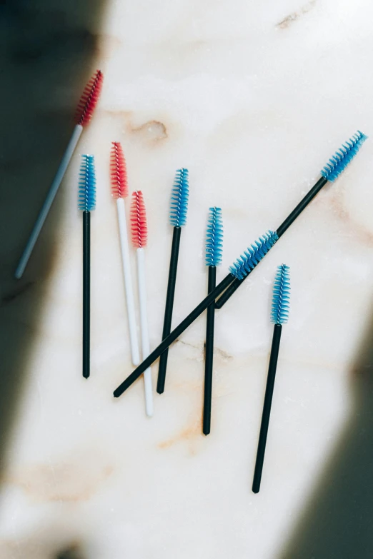 a group of toothbrushes sitting on top of a counter, a colorized photo, unsplash, plasticien, made of lab tissue, thin spikes, blue-black, straw