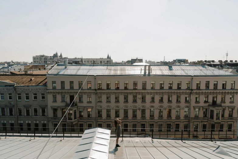 a couple of benches sitting on top of a roof, by Emma Andijewska, pexels contest winner, khreschatyk, building facing, dezeen, full daylight