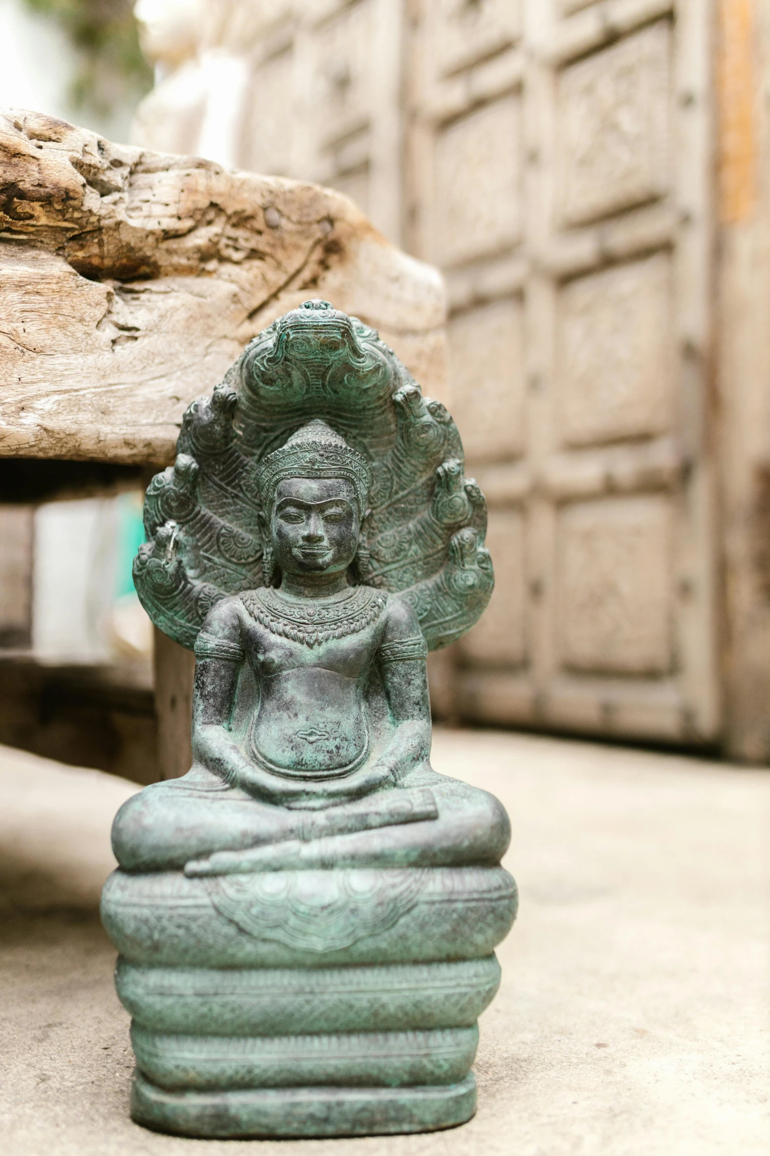 a statue of a person sitting in a lotus position, unsplash, fine art, cambodia, on wood, verdigris, handcrafted