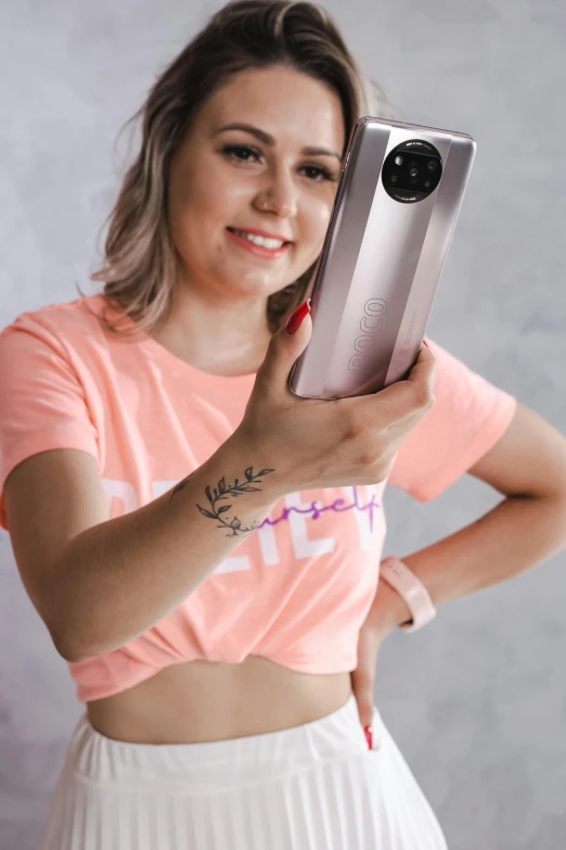 a woman taking a picture of herself with a camera, a colorized photo, by Emma Ríos, trending on pexels, holography, posing with crossed arms, croptop, droid, woman is curved