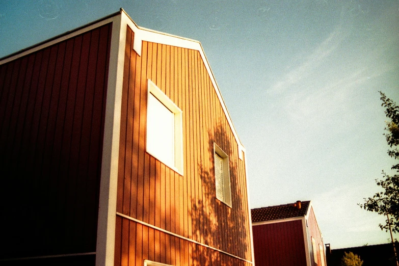 a building with a fire hydrant in front of it, inspired by Wilhelm Marstrand, solarised, barn, photo taken on fujifilm superia, reddish exterior lighting