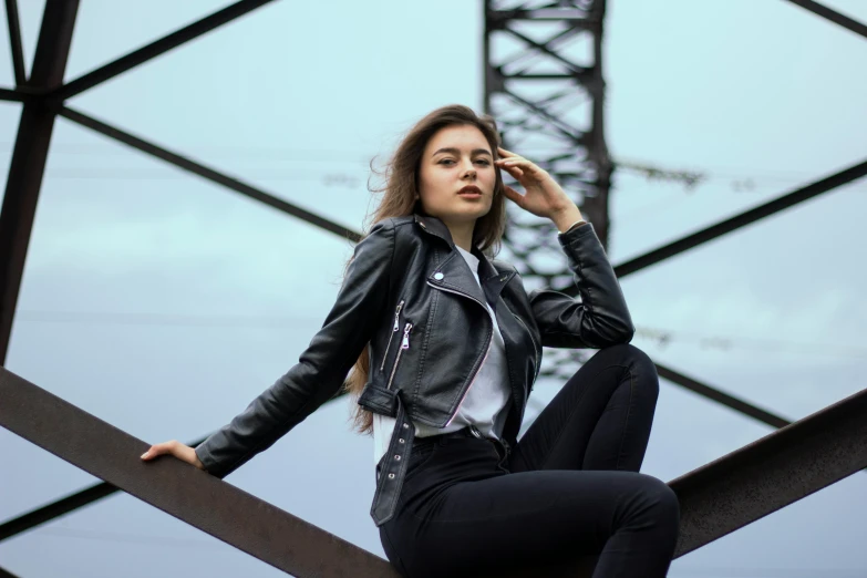 a woman sitting on top of a metal structure, pexels contest winner, photorealism, leather jackets, profile image, model standing pose, photoshoot for skincare brand
