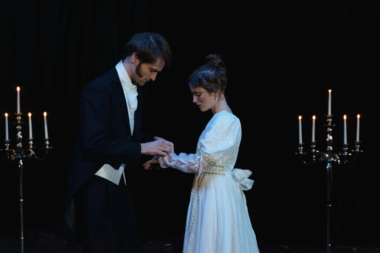 a man in a tuxedo putting a ring on a woman's finger, a portrait, by Alice Mason, pexels contest winner, romanticism, high quality theatre costume, kiera knightly in repose, profile image, both wearing victorian clothes