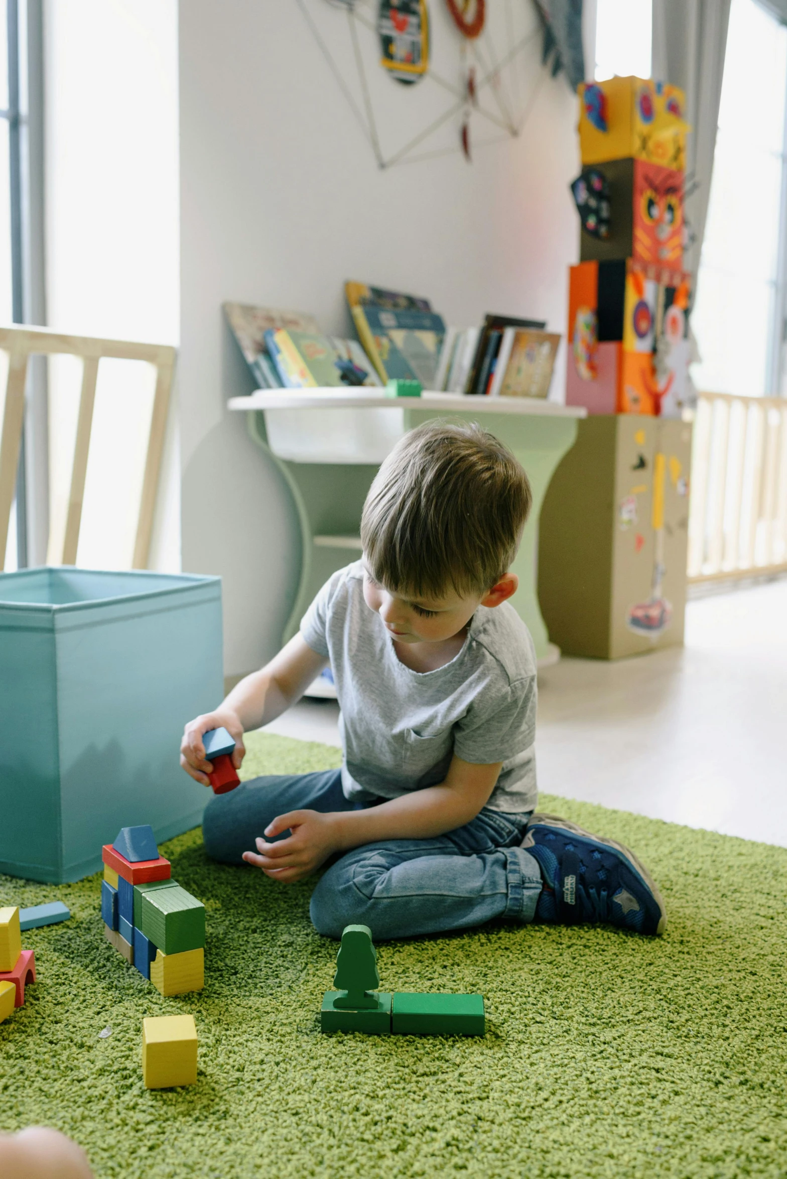 a little boy sitting on the floor playing with blocks, by Sebastian Vrancx, pexels contest winner, small library, square, toy room, gif